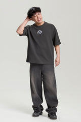 Model wearing gray loose tee with white logo print