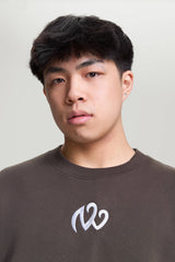 Close-up of model wearing gray NV Loose Sweatshirt with embroidered white logo