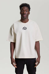 Front view of beige NV Loose T-Shirt with black embroidered logo by TURN ENVY TO LOVE