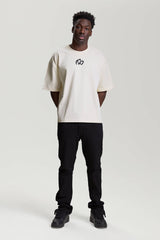 Model wearing beige NV Loose T-Shirt with black logo by TURN ENVY TO LOVE