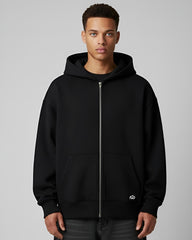 Male model front view in black zip hoodie with white logo and silver zipper