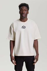 Front view of beige NV Loose T-Shirt with black embroidered logo by TURN ENVY TO LOVE